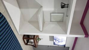 A room with a white wall, a wooden chair, a small table with a plant, a window with a view, and a door. - Zac NicteMx House / ESTUDIO SISAL (Cancun)