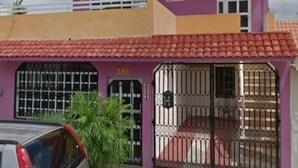A two-story building with a purple facade and a red-tiled roof. - Zac NicteMx House / ESTUDIO SISAL (Cancun)