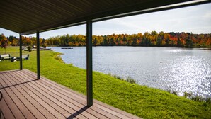 Una terrazza coperta con vista su un lago e il fogliame autunnale.