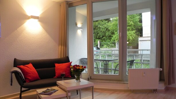 Una sala moderna con un sofá, una mesa de centro y un jarrón de flores.