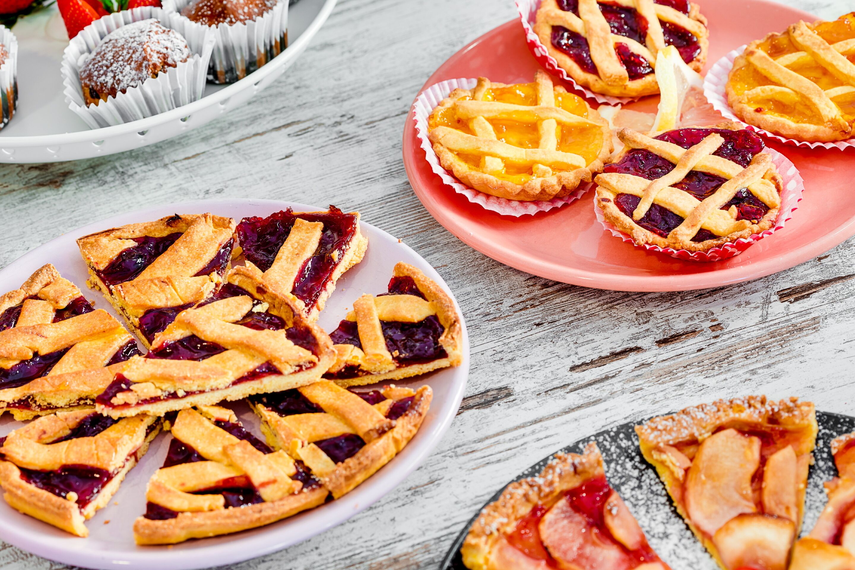 Verschiedene Kuchen auf Tellern und Tabletts.