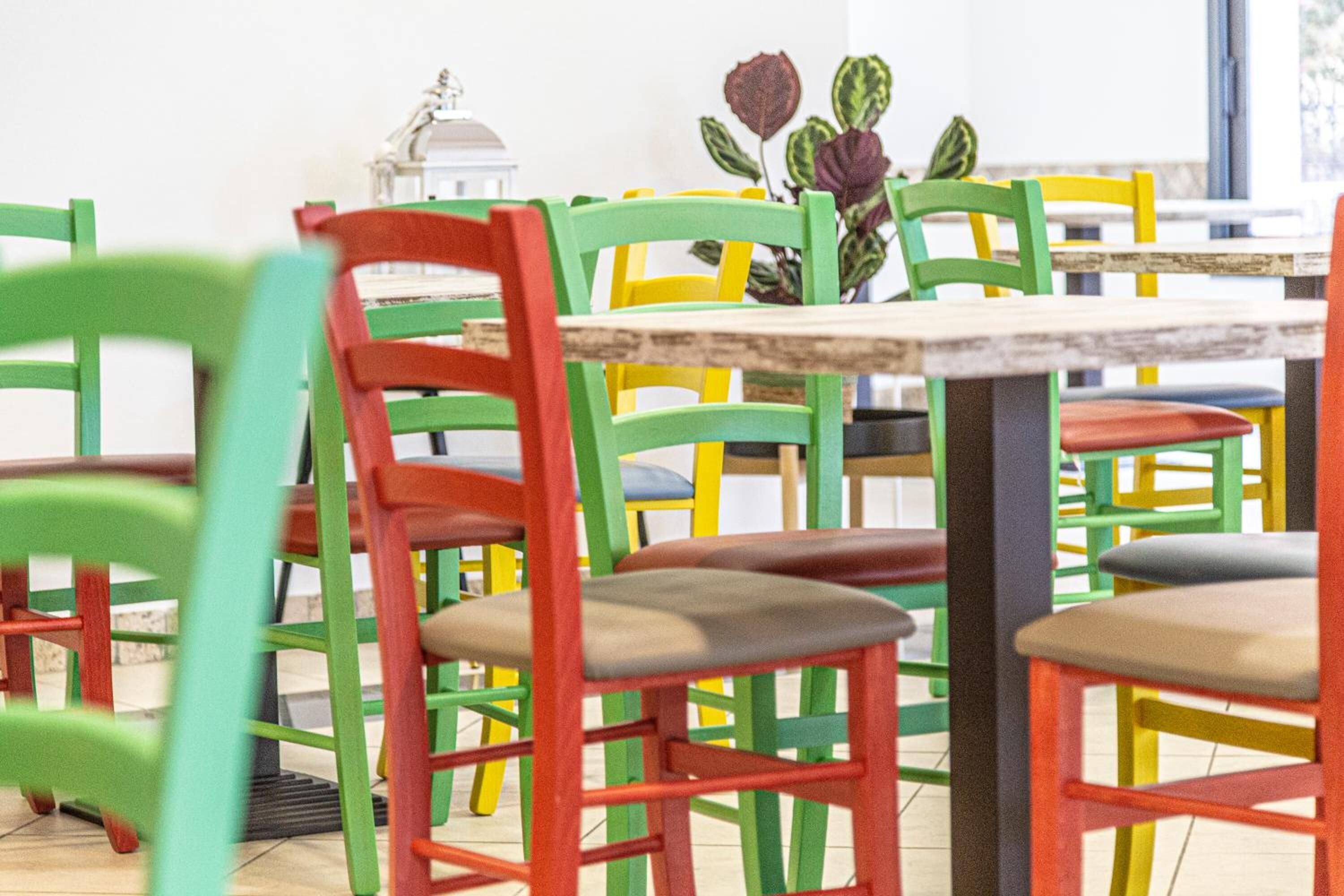 Un coin repas avec des chaises colorées et une table.
