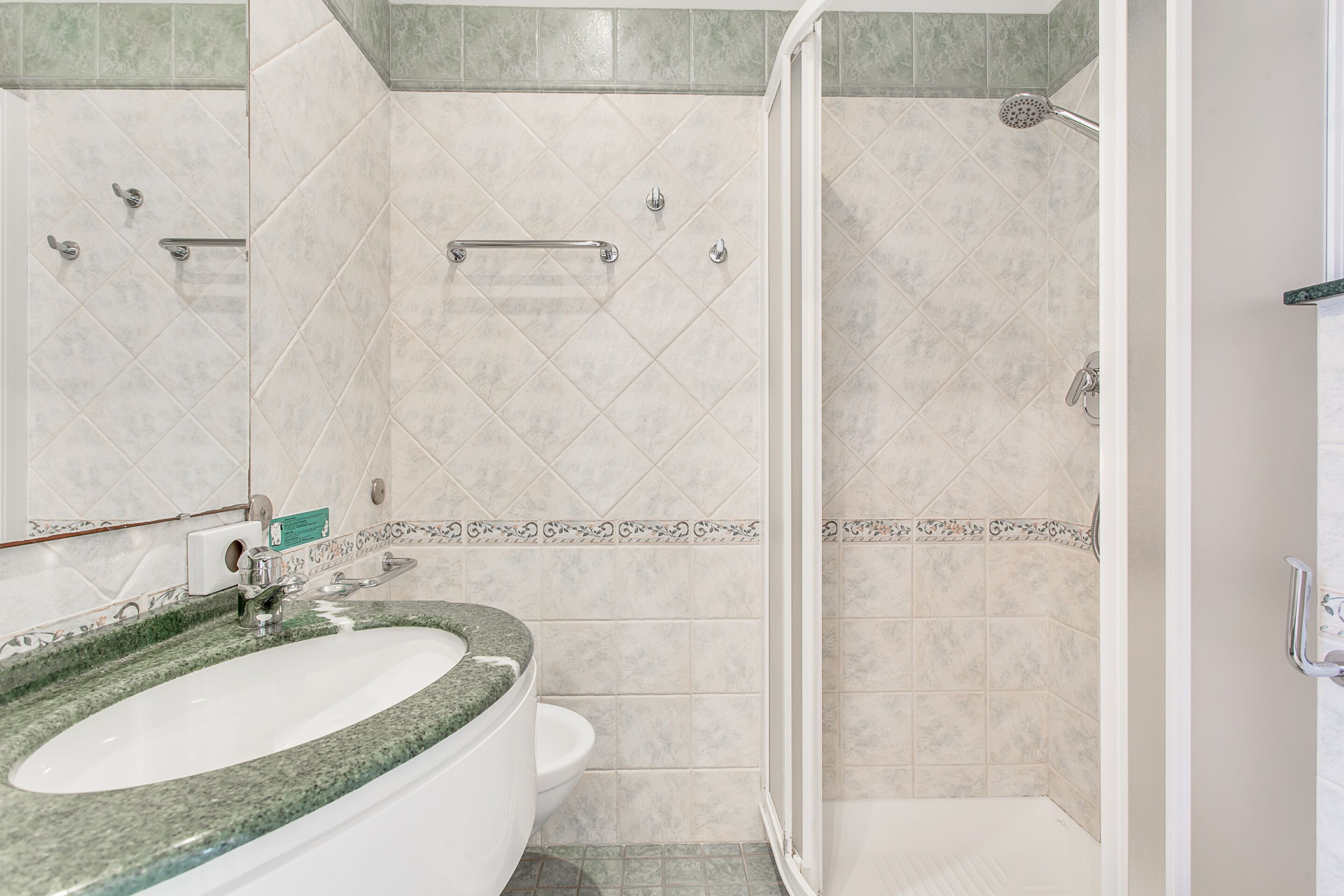 A bathroom with a sink, toilet, and shower.