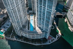 A high-rise building with a central courtyard, a swimming pool, and a marina.