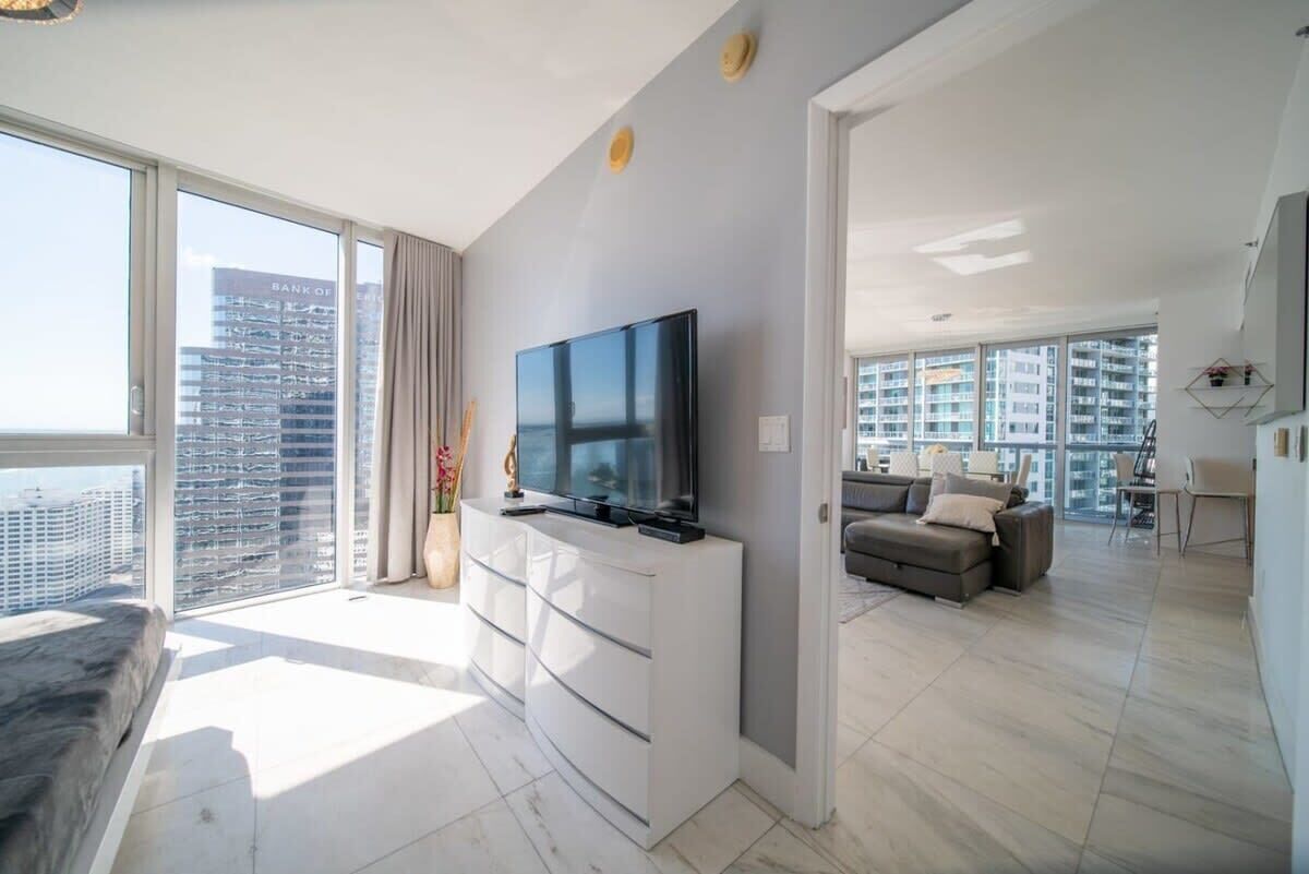 Un appartement moderne doté d’une grande télévision, d’un canapé et d’un coin repas.