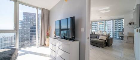Un appartement moderne doté d’une grande télévision, d’un canapé et d’un coin repas.
