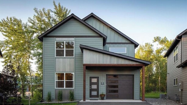 A two-story house with a garage, a front porch, and a driveway. - Rainbow Haven down by the Gallatin River (Bozeman)