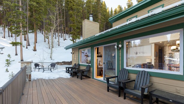 A wooden deck with outdoor seating and a view of a mountain forest. - 8 Crown Drive by Summit County Mountain Retreats (Breckenridge)