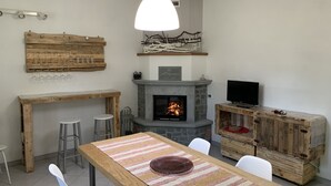 Una sala de estar acogedora con chimenea, muebles de madera y televisor.