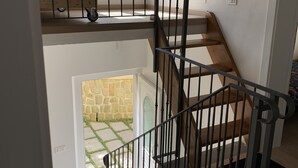 Una escalera de varios niveles con detalles de madera y barandillas de metal negro.