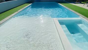 Una piscina al aire libre, una piscina climatizada