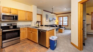 A modern kitchen with wooden cabinets, stainless steel appliances, and a granite countertop.