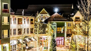 Een meerlaags gebouw met een centrale binnenplaats, met een kleine kerstboom en een terras.