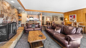 A cozy living room with leather sofas, a coffee table, and a stone fireplace. - Decatur #1787 by Summit County Mountain Retreats (Keystone)