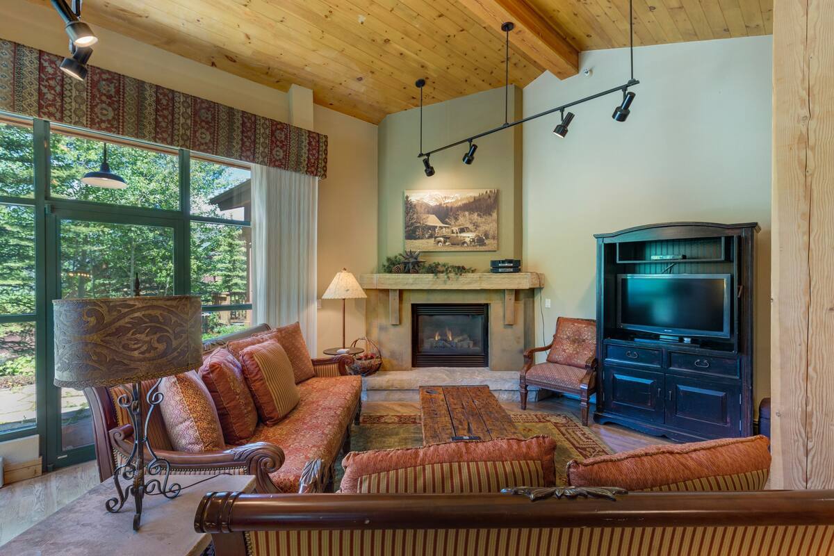 A cozy living room with a fireplace, comfortable seating, and a television.