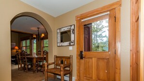 A wooden door with a mirror, a dining area with chairs and a table, and a chandelier. - Trapper's Crossing #8770 by Summit County Mountain Retreats (Keystone)