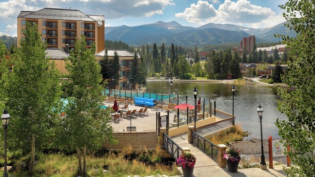 A hotel with a pool area, surrounded by mountains and a lake. - Water House #6204 by Summit County Mountain Retreats (Breckenridge)