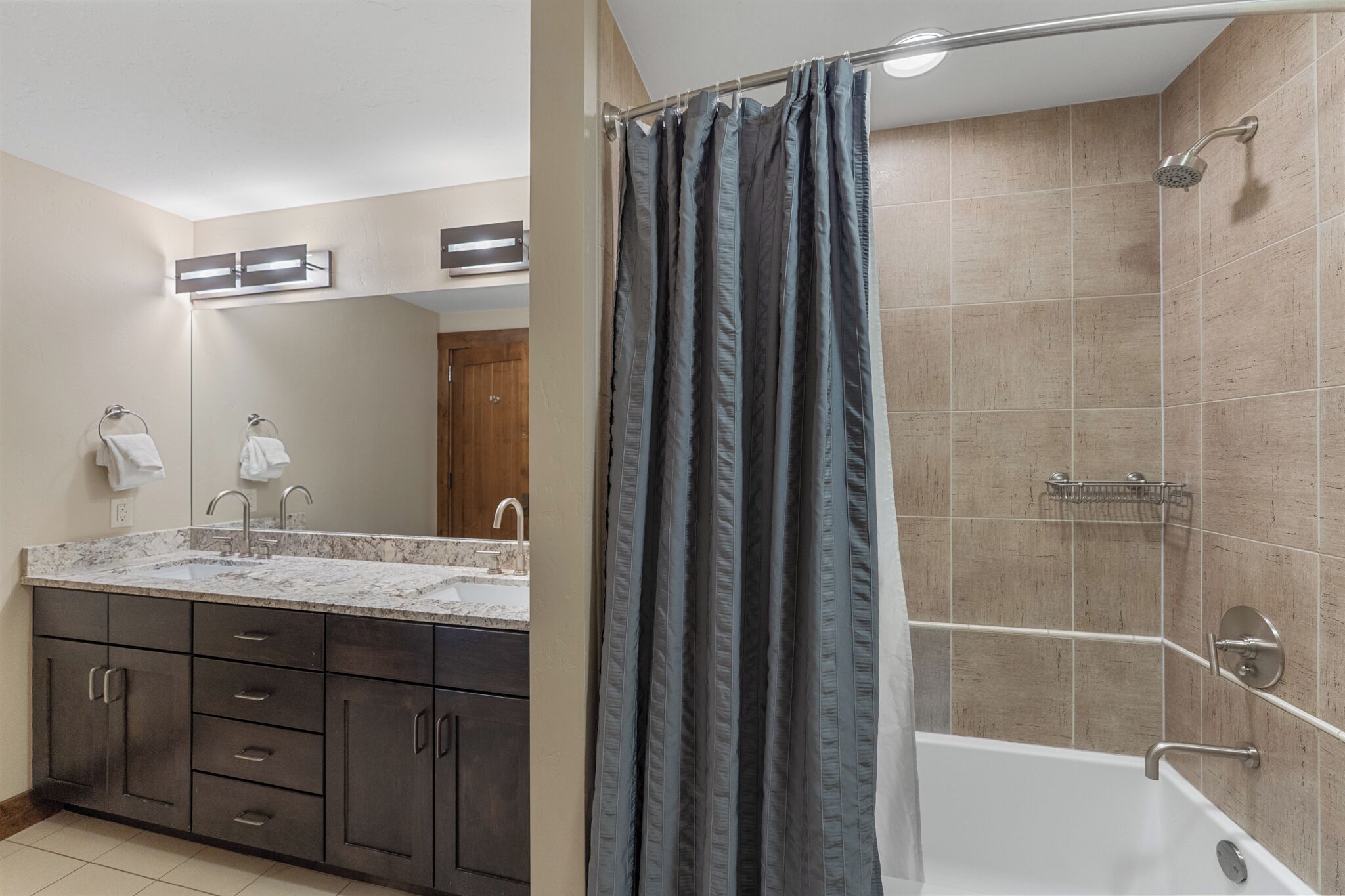 Un baño con lavabo, espejo y zona de ducha.