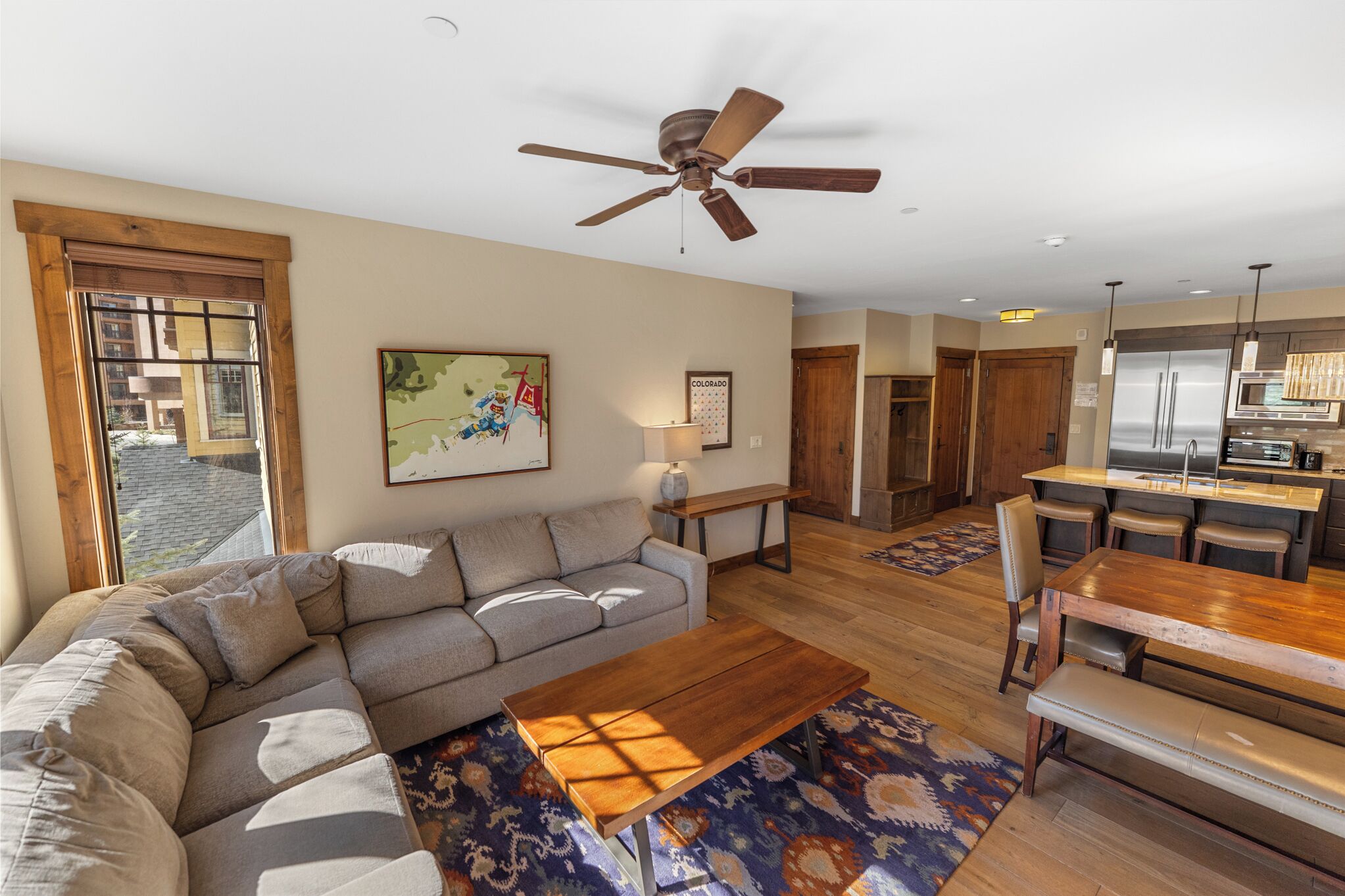 A living room with a sofa, coffee table, and a dining area with a wooden table and chairs.