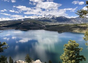 Ein ruhiger See, umgeben von Bergen und Bäumen.