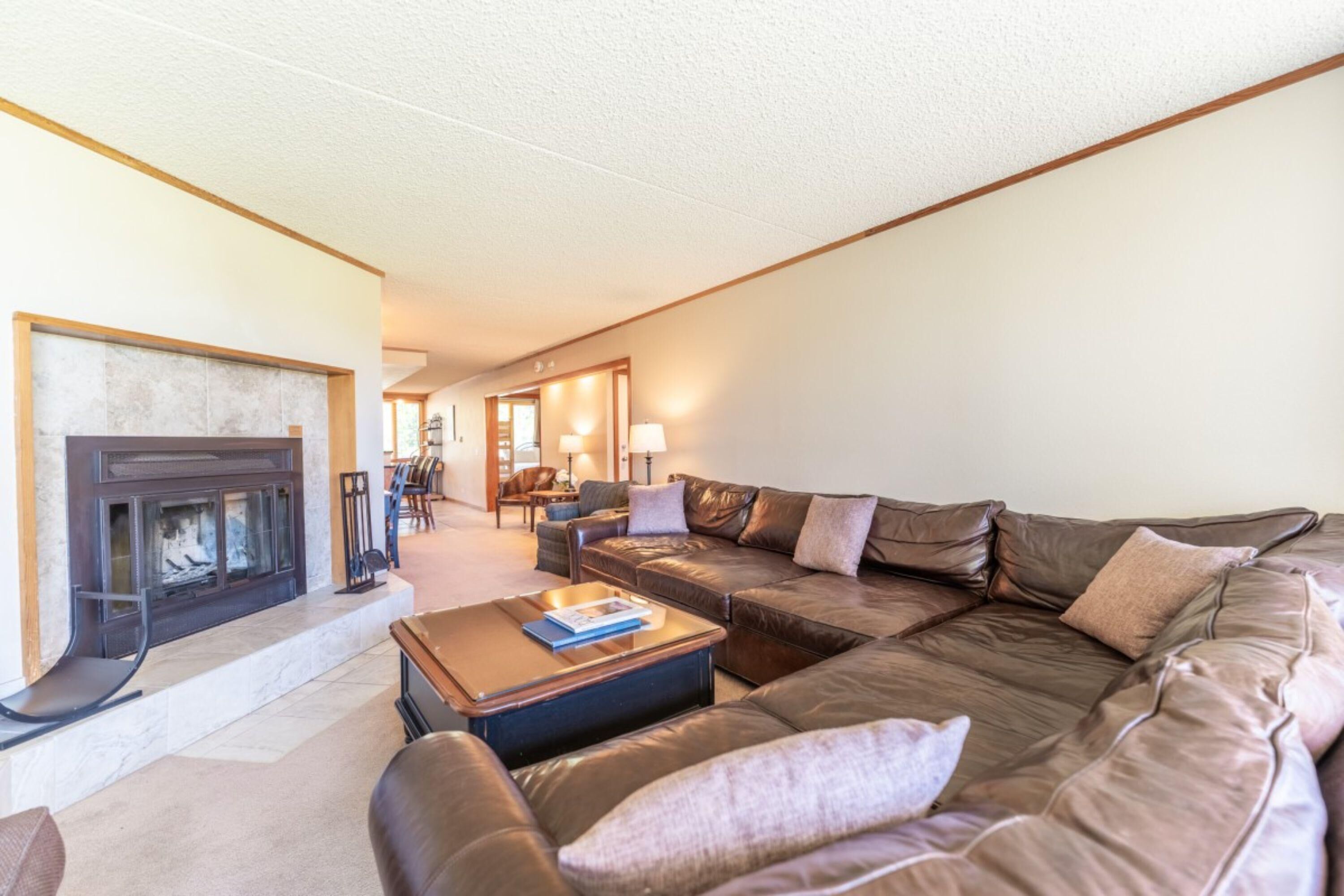A living room with a fireplace, leather sofa, and a coffee table.