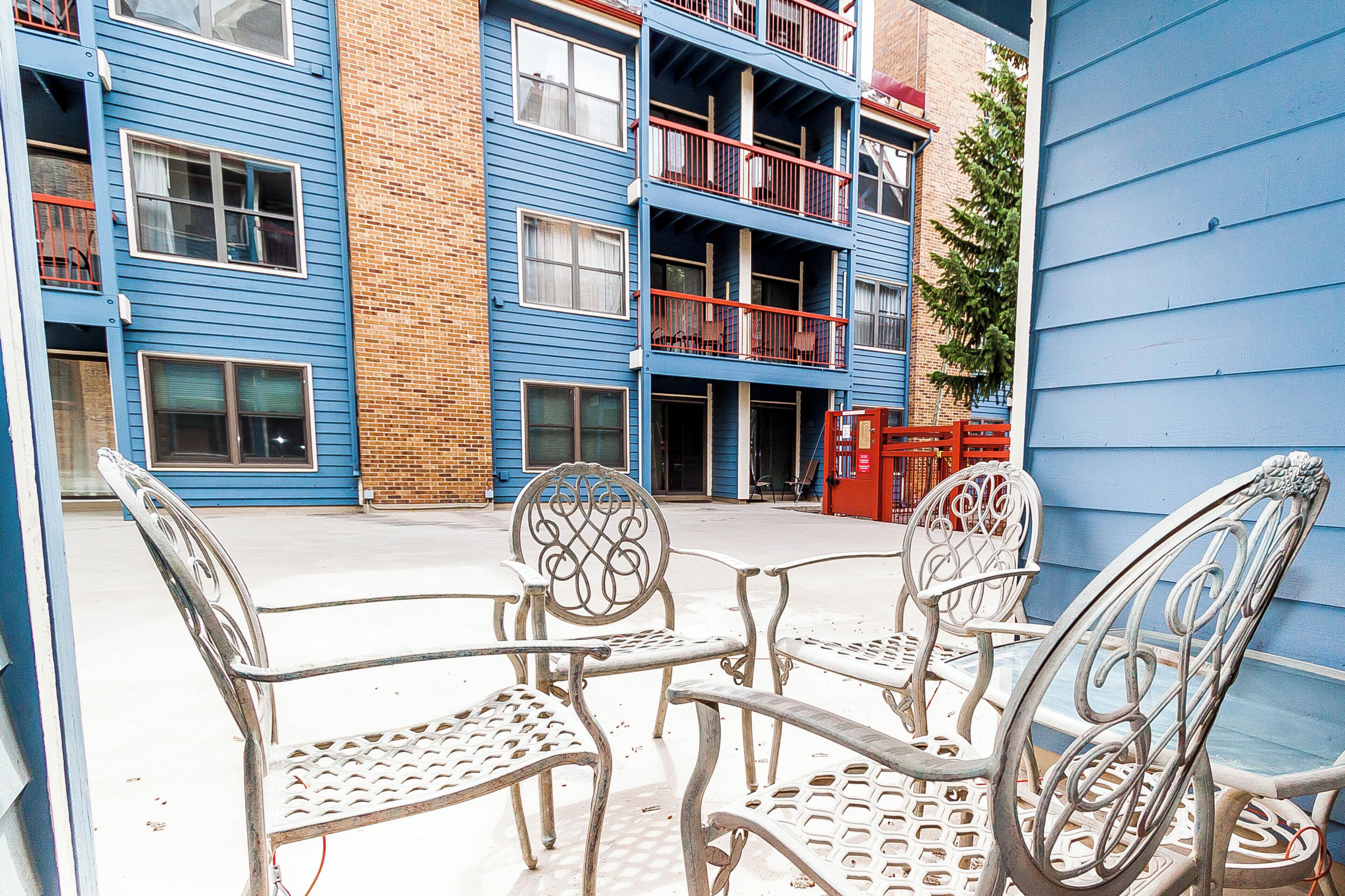 A courtyard with metal chairs and a red fire hydrant.