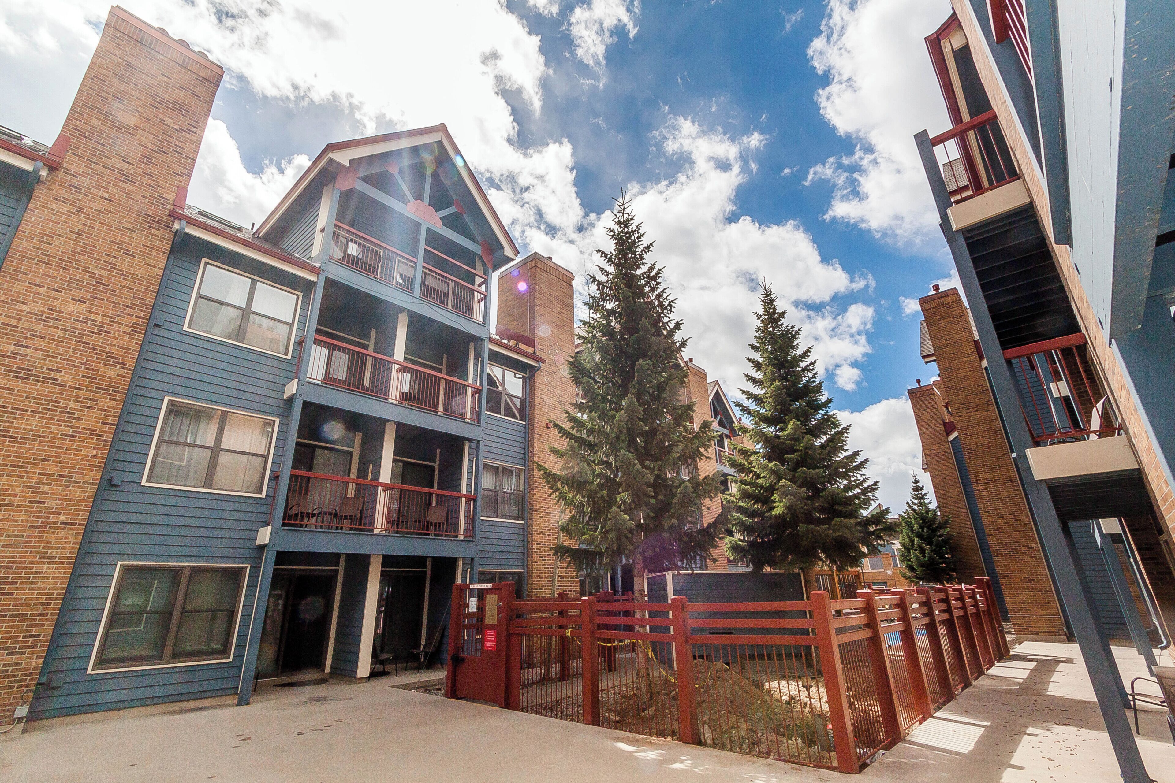 A multi-story residential building with a brick facade, large windows, and a balcony.