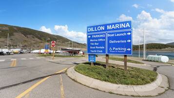 A marina sign with directions to parking, boat launch, deliveries, and a yacht club.