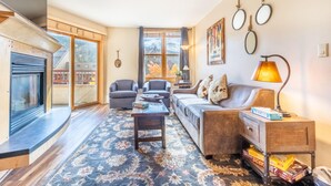 A living room with a fireplace, sofas, a coffee table, and a rug. - Silver Mill by Summit County Mountain Retreats (Keystone)