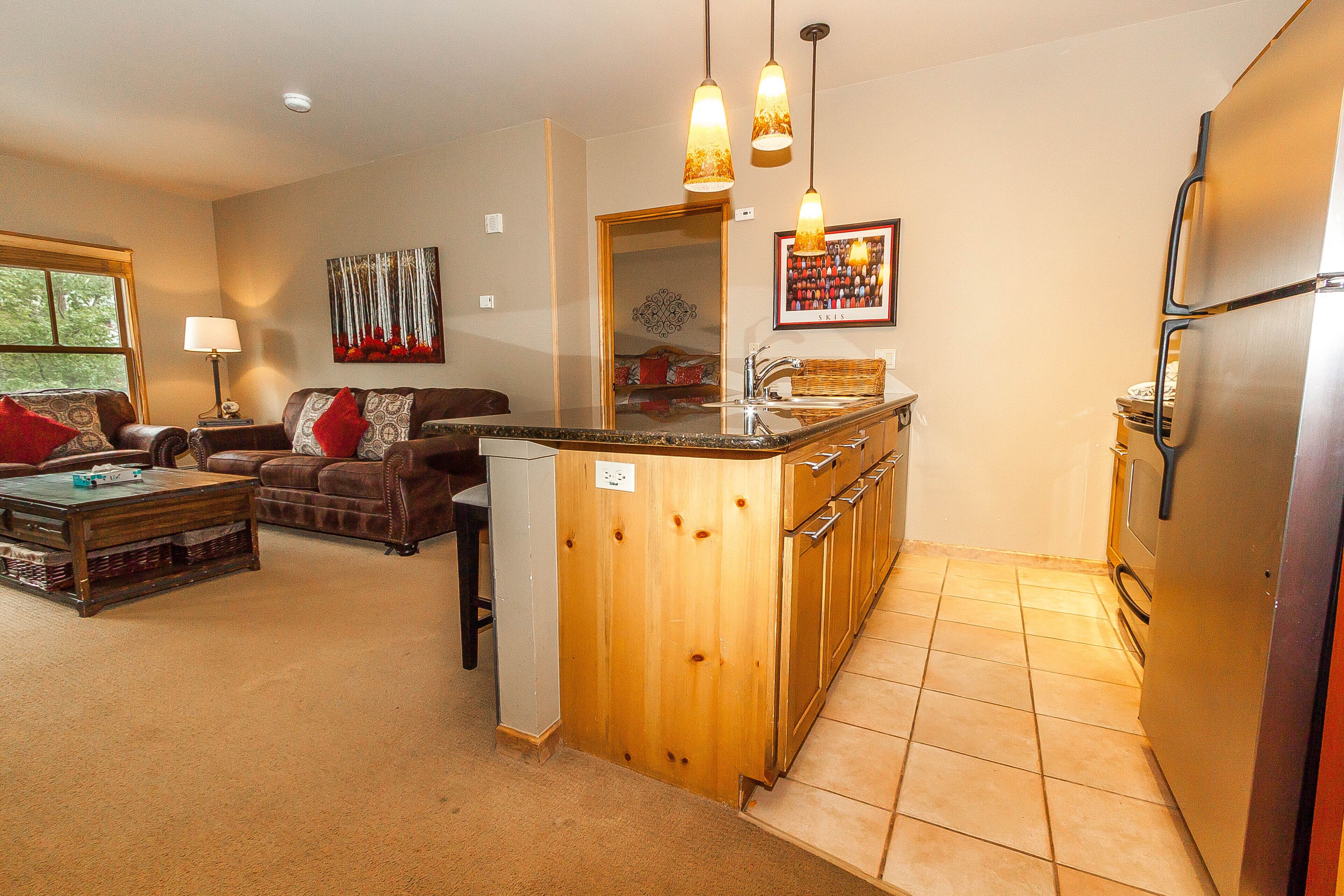 Un espacio habitable compacto con kitchenette, comedor y sofá.