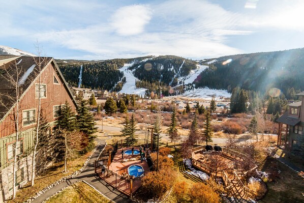 A ski resort with a large building, a pool area, and a view of a snowy mountain. - Tenderfoot Lodge by Summit County Mountain Retreats (Keystone)