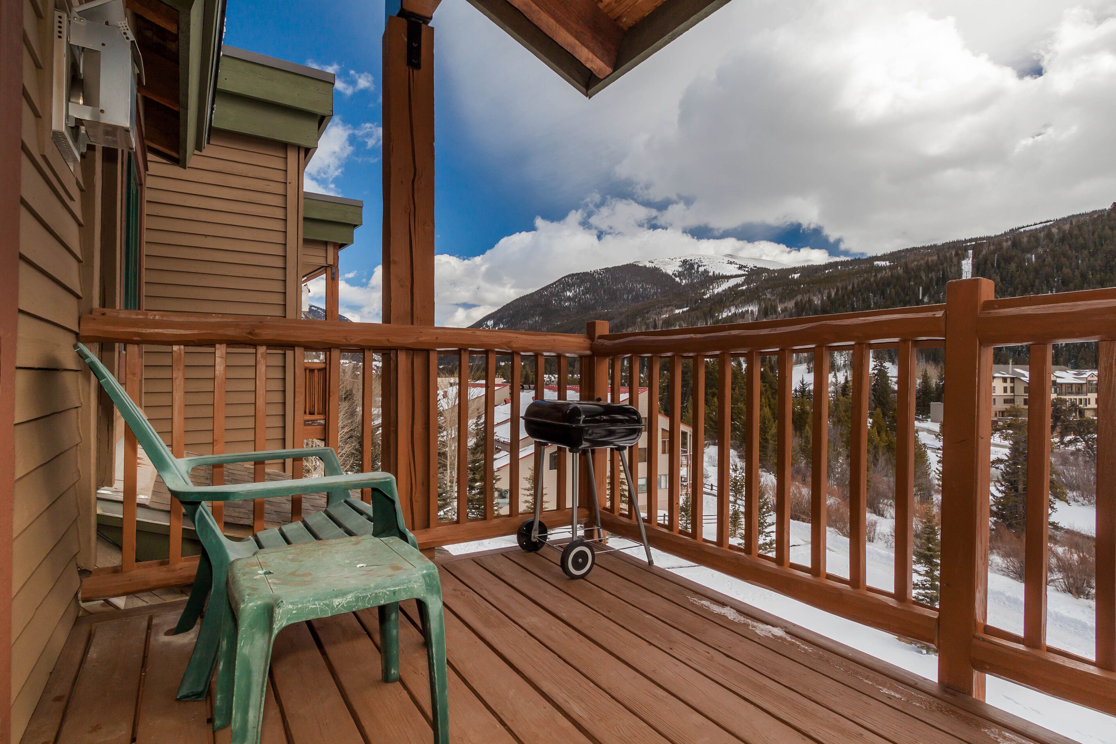 A wooden deck with a view of snow-covered mountains.