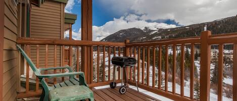 A wooden deck with a view of snow-covered mountains.