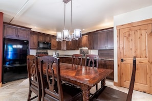 Una cocina amplia con armarios de madera, una gran mesa de comedor y un microondas integrado.