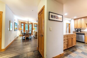 A spacious kitchen with wooden cabinets and a dining area with a table and chairs. - Timbers #3078 by Summit County Mountain Retreats (Keystone)