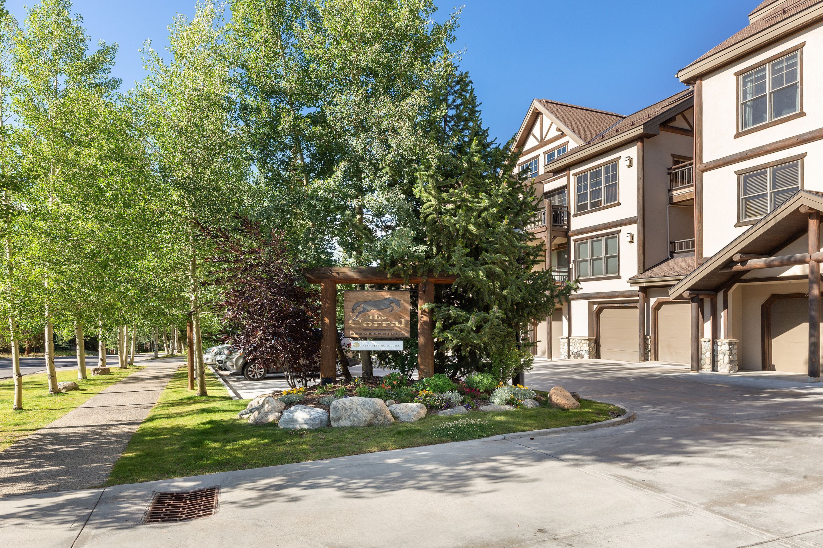 A residential area with a well-maintained lawn, a stone pathway, and a signboard.