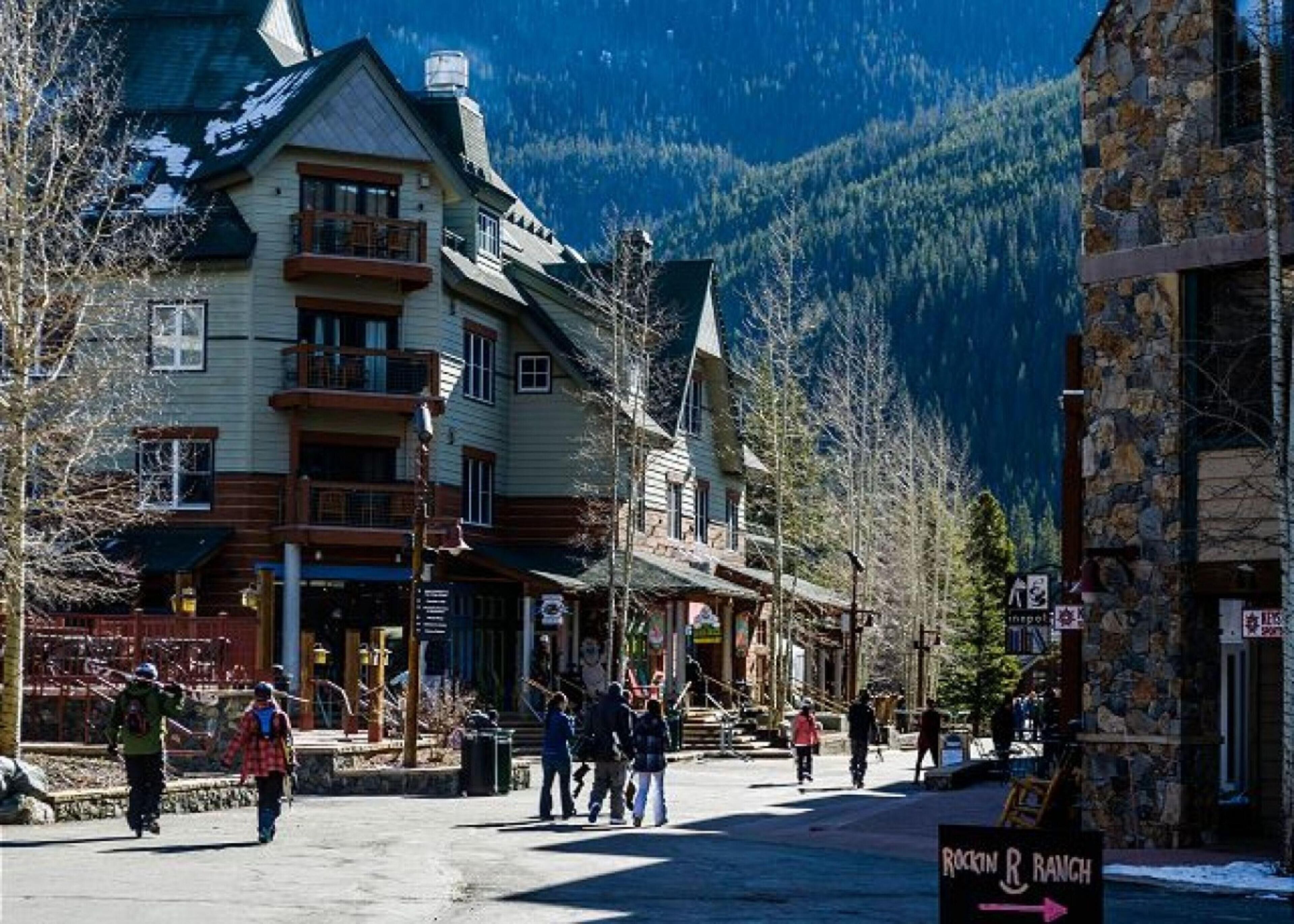 A building with a wooden facade, multiple balconies, and a mountain backdrop.
