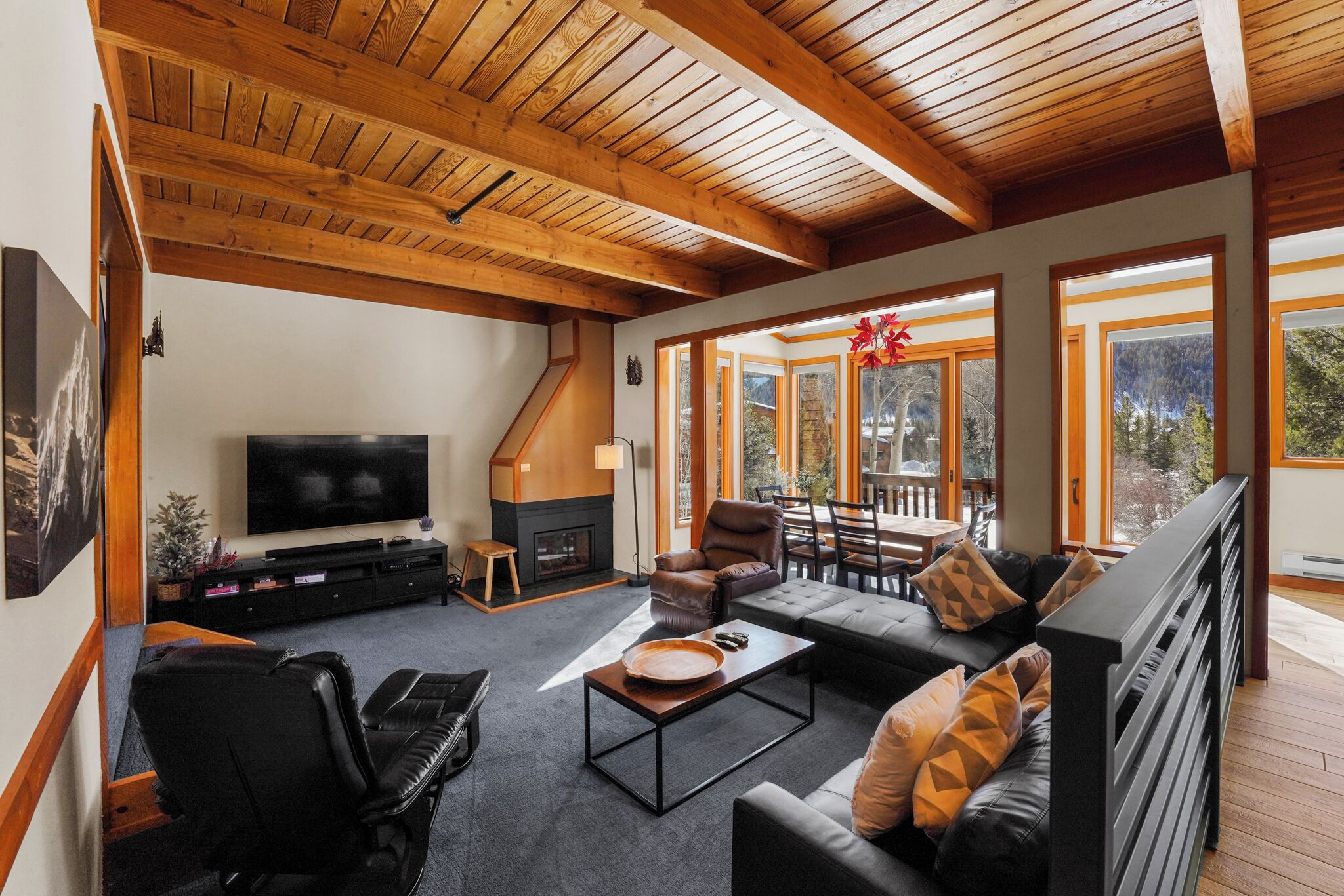 A spacious living room with a fireplace, a large TV, and comfortable seating.