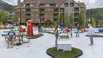 Een hotel met meerdere verdiepingen, recreatieve buitenruimtes en uitzicht op bergen.