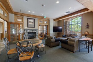 A spacious living area with a stone fireplace, a television, and comfortable seating. - Buffalo Lodge by Summit County Mountain Retreats (Keystone)