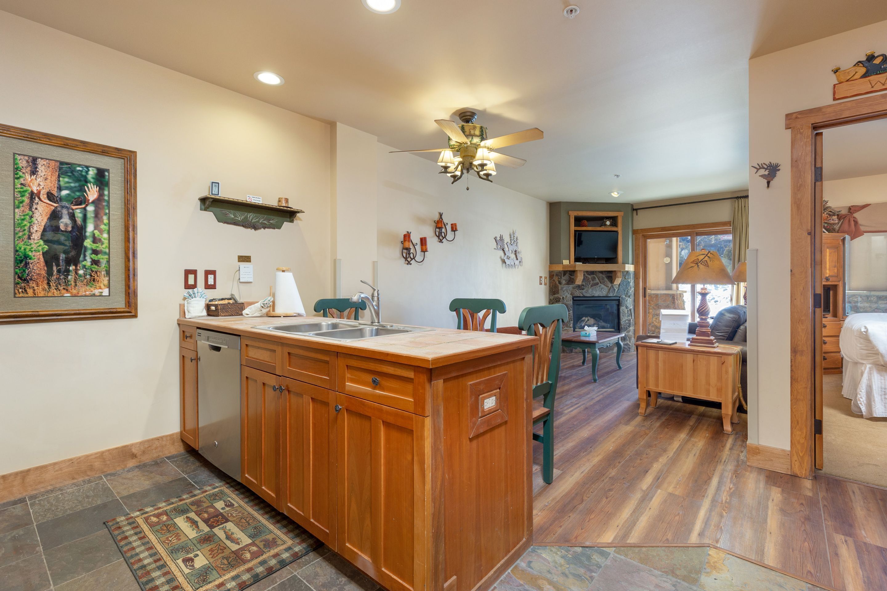A spacious kitchen with wooden cabinets, a central island, and a dining area with a table and chairs.