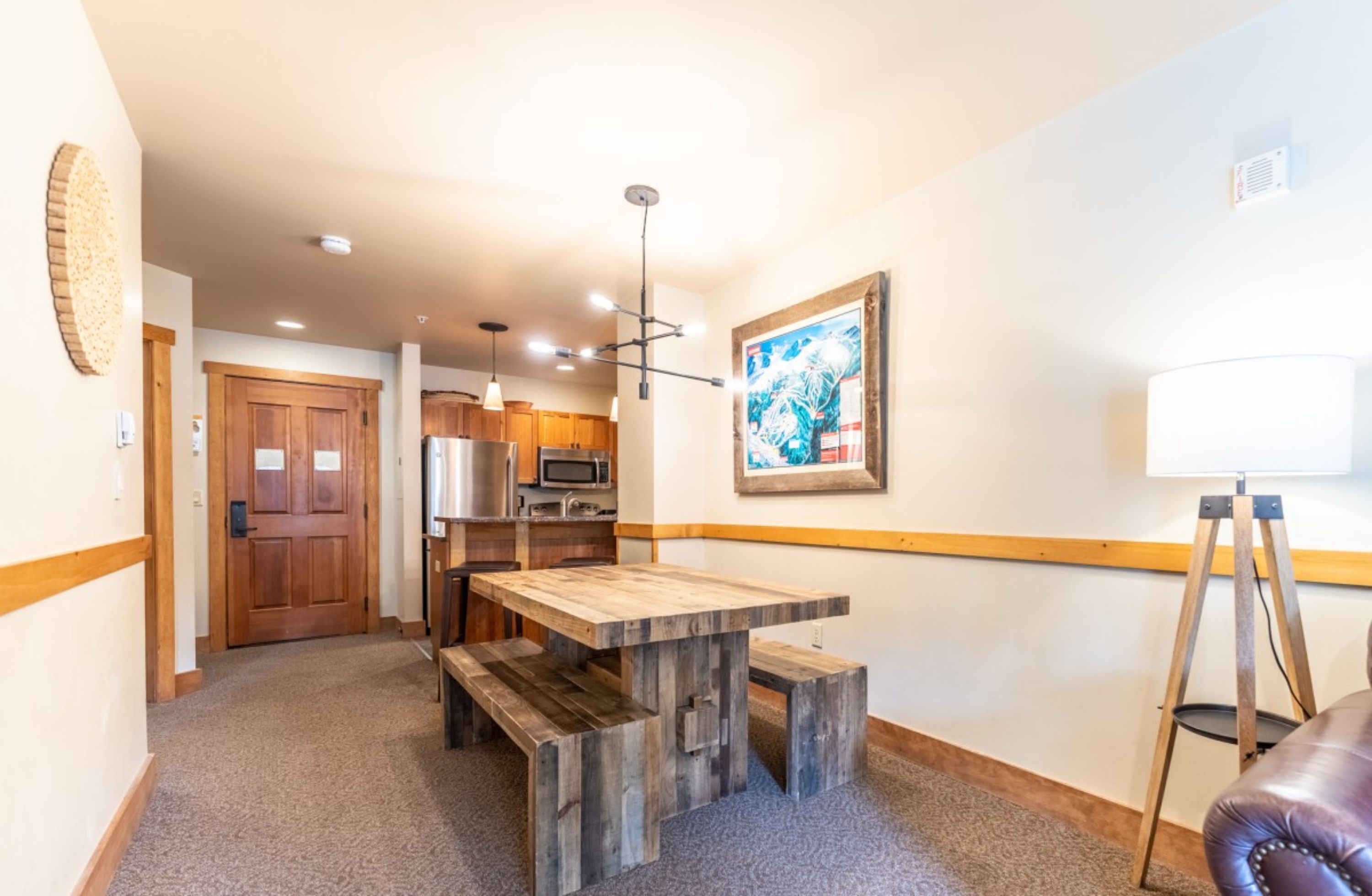 A cozy kitchen with wooden cabinets, a built-in microwave, and a pendant light.