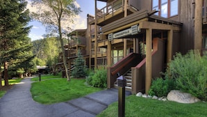 Un chalet à étages, doté de balcons en bois et d’un escalier menant à l’entrée.