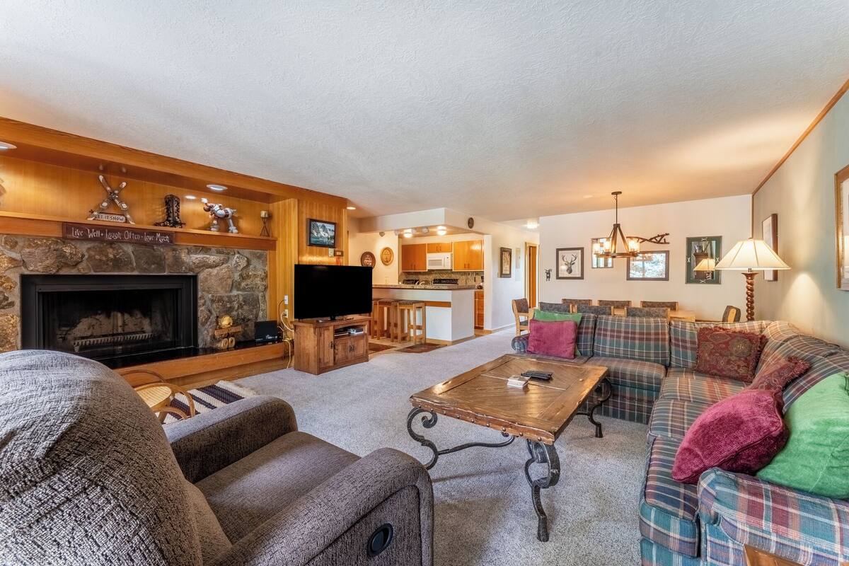 A cozy living room with a fireplace, a television, and a sofa set.