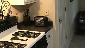 A kitchen with a stove, toaster, and cabinets.