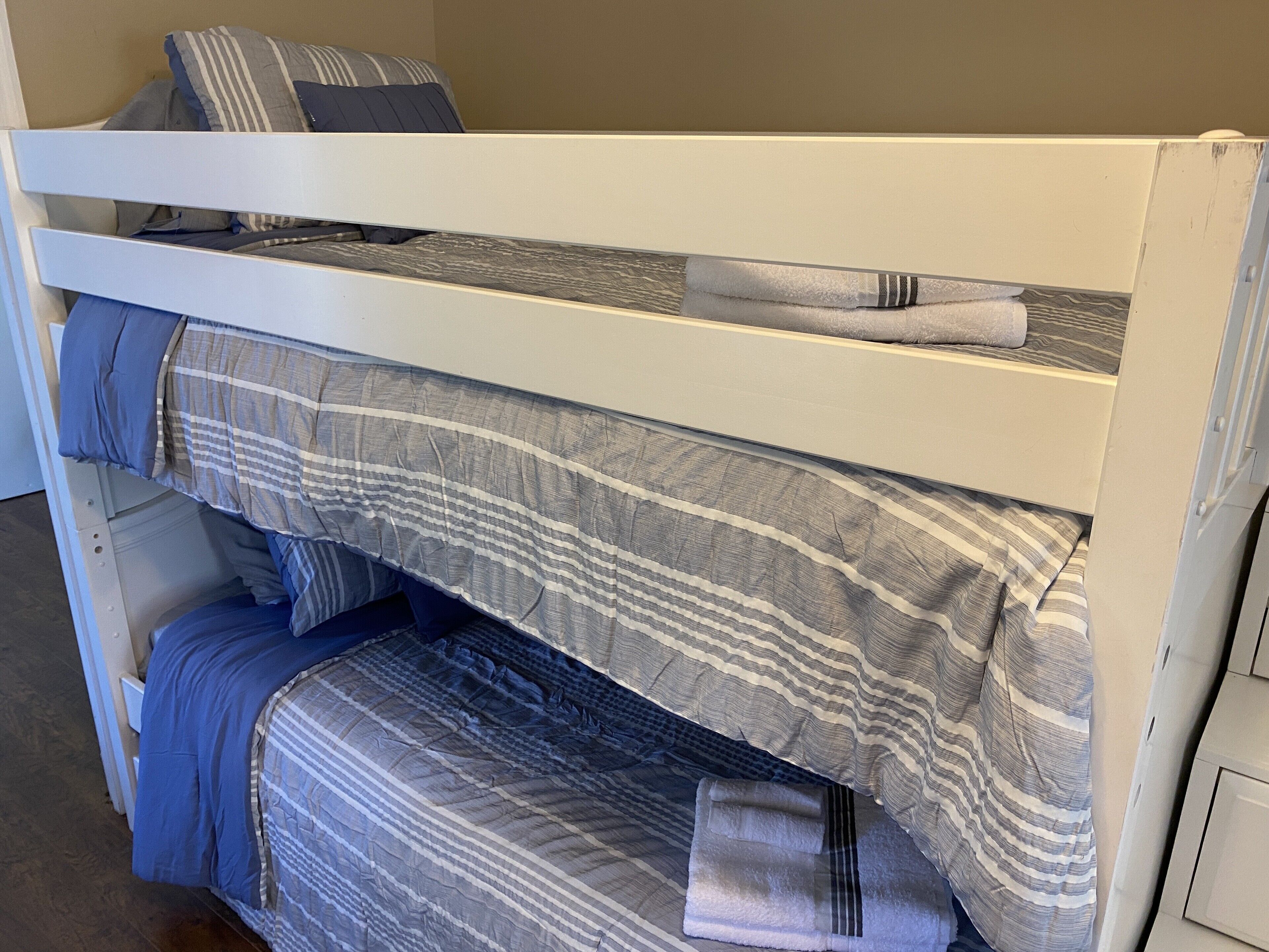 A bunk bed with striped bedding and pillows.