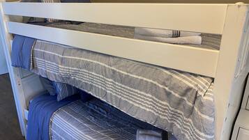 A bunk bed with striped bedding and pillows.