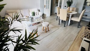 Una sala moderna con sofá, mesa de centro y comedor.