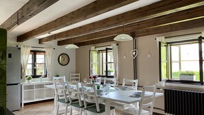 A dining area with a white table and chairs, a clock on the wall, and a window with curtains. - Holiday home Lipno, Slupečná (Lipno nad Vltavou)