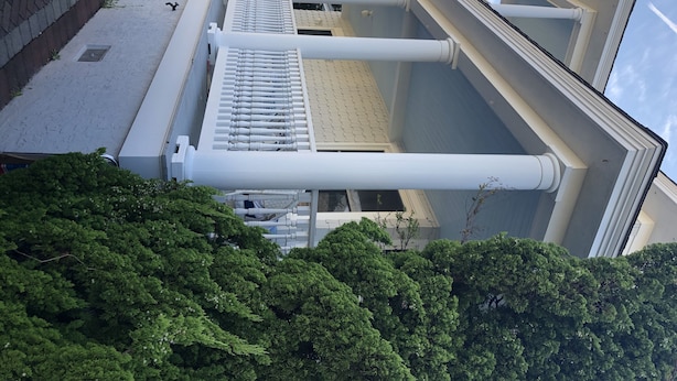 A modern building with a flat roof, large white columns, and a metal railing. - Close to beautiful beach (Avalon)
